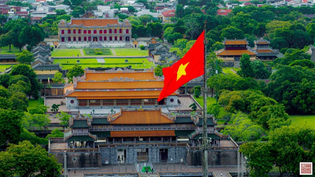 A traditional Vietnamese temple complex with a prominent flag. 3