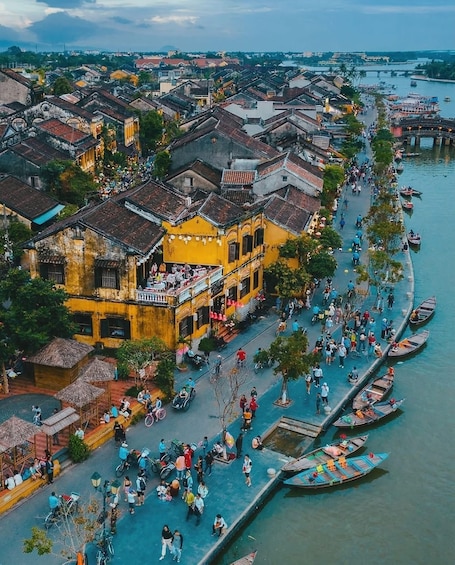 A bustling riverside town with historic buildings and a lively crowd. 5