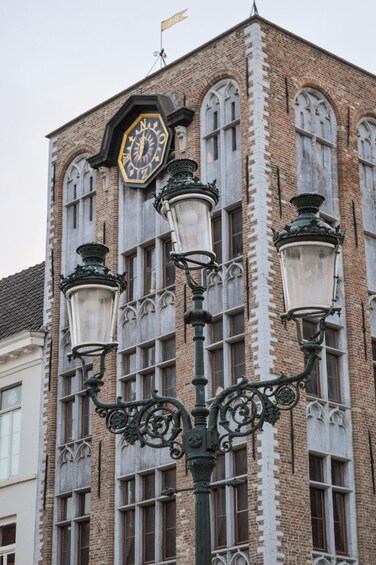A historic building with a clock, ornate street lamps, and arched windows. 4