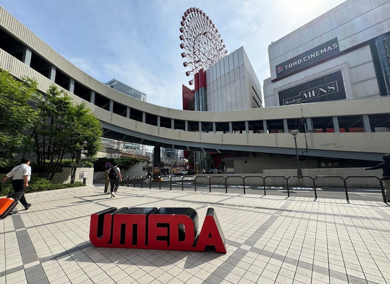 A modern urban plaza with a Ferris wheel, a cinema, and a large red 'UMEDA' sign. 2