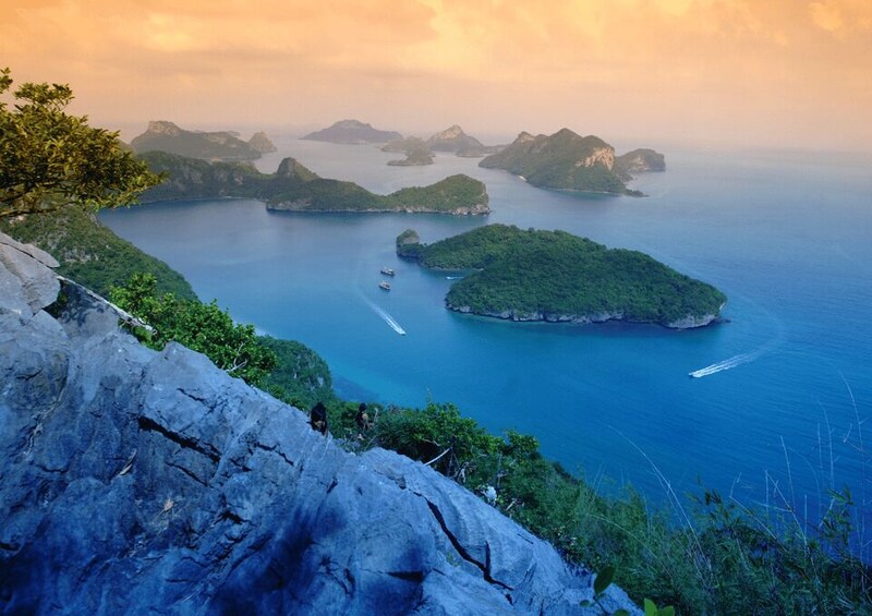 A coastal landscape with rocky cliffs, a clear blue sea, and several small islands. 3