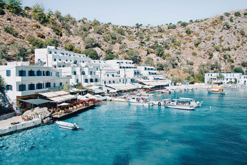 A coastal town with white buildings, a marina, and boats. 1