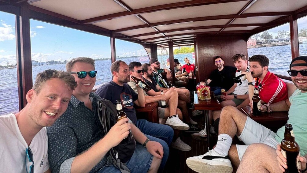 A group of people on a boat with a view of a body of water and a distant shoreline. 2