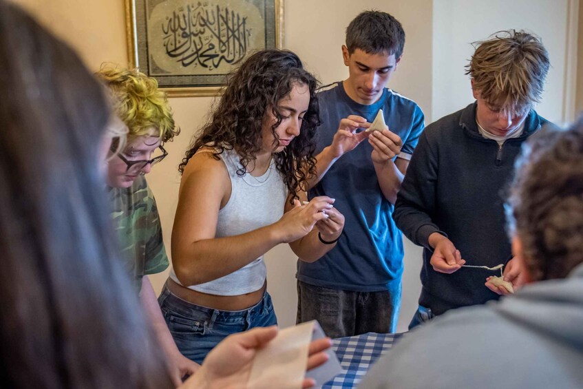 A group of people engaged in a discussion around a table with a checkered tablecloth. 3