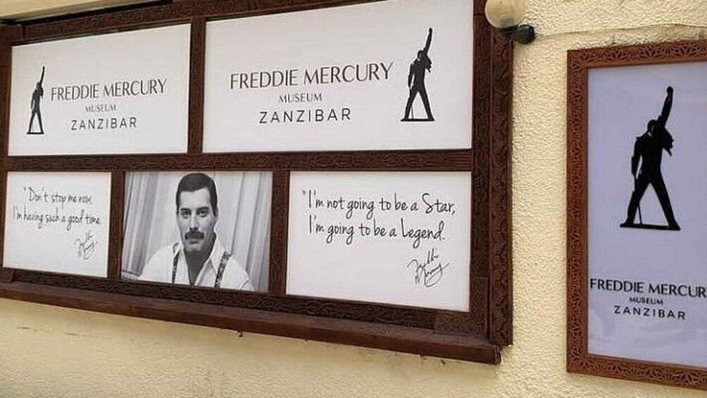 A wall with multiple framed items, including text and silhouettes, related to Freddie Mercury and the Freddie Mercury Museum in Zanzibar. 4