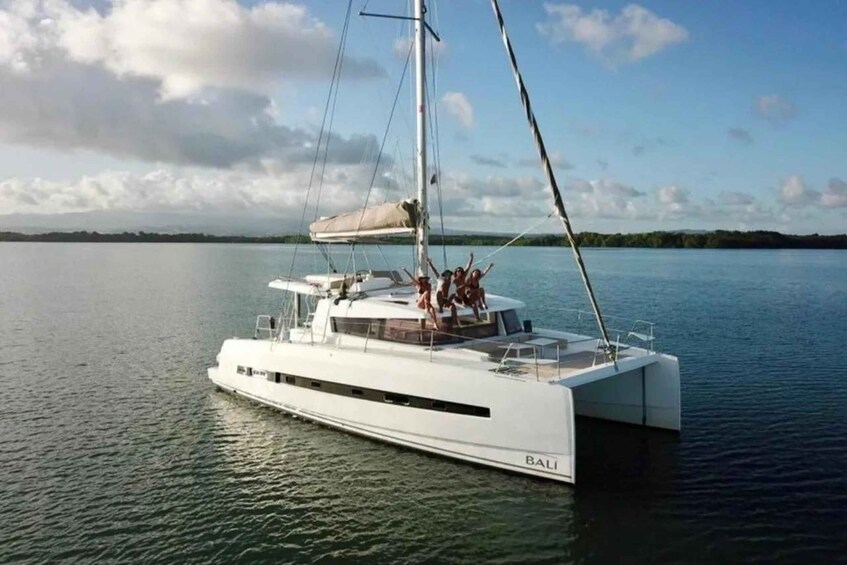A white yacht named 'BALI' on calm waters with a clear sky and distant land. 4