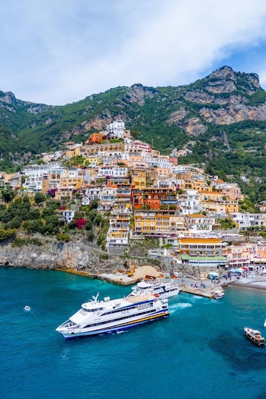 A coastal town with colorful buildings and a cruise ship docked at the harbor. 3