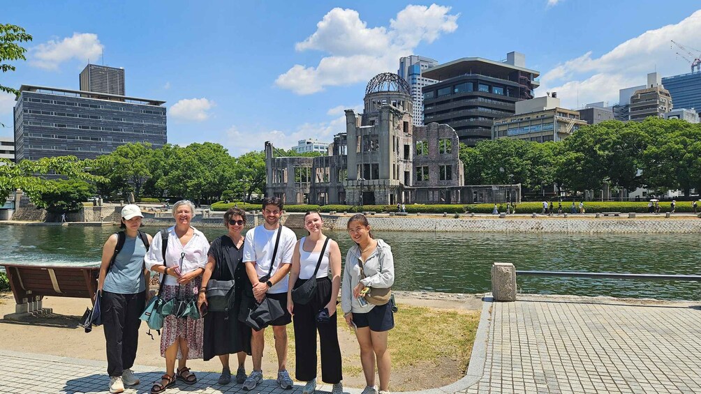 A group of people standing by a waterfront with a cityscape in the background. 4