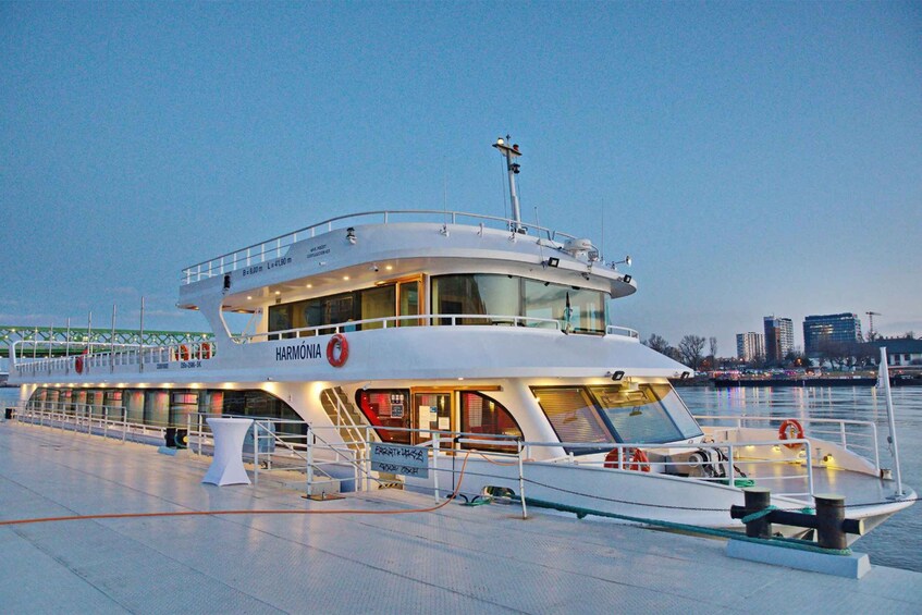 A large, modern cruise ship docked at a port with a city skyline in the background. 4