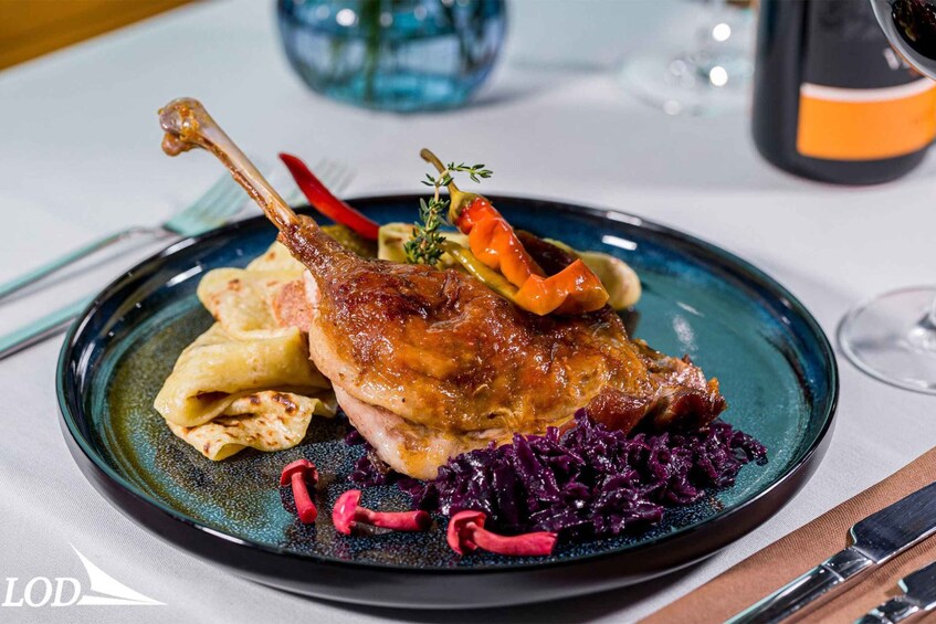 A plate of duck with vegetables and red cabbage. 1