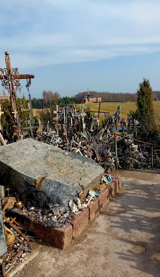 A cluttered outdoor area with various objects and debris, including a large stone slab and metal structures. 1