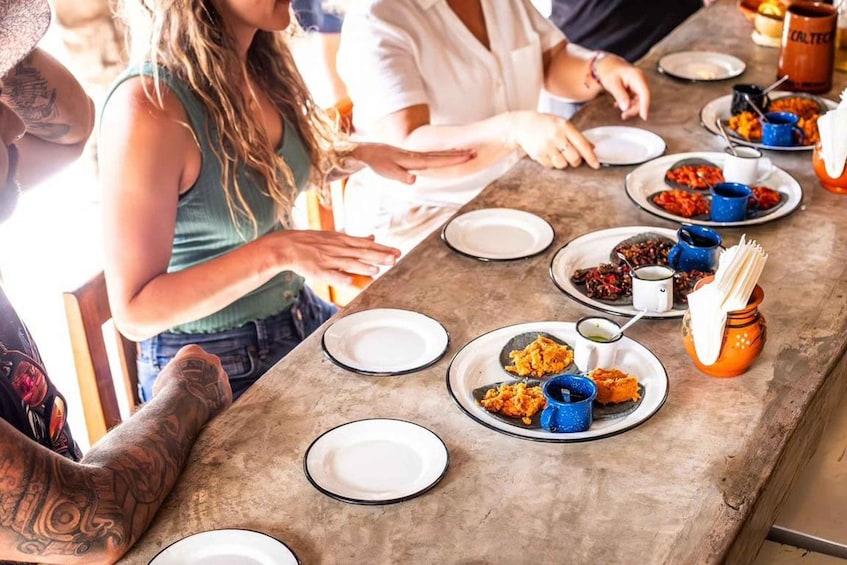 A group of people at a dining table with various dishes and drinks. 5