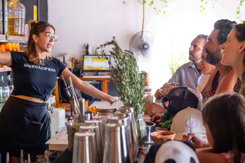 A barista serving coffee to customers in a modern cafe with a computer monitor and plants in the background. 4