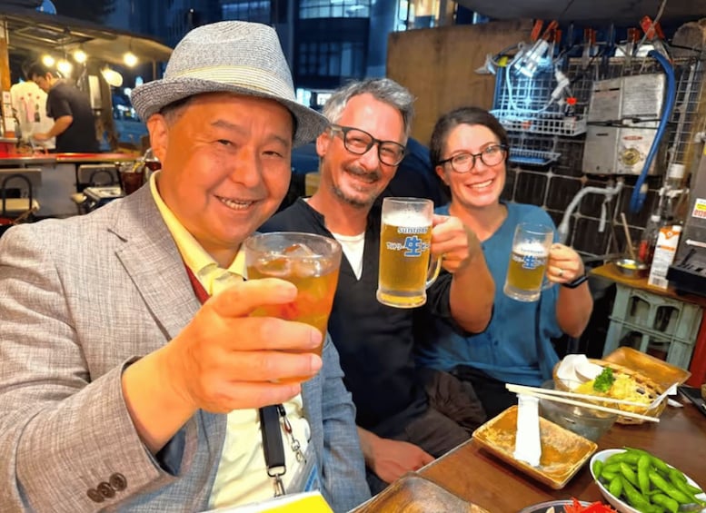 Three people toasting with beer mugs in a restaurant setting. 2