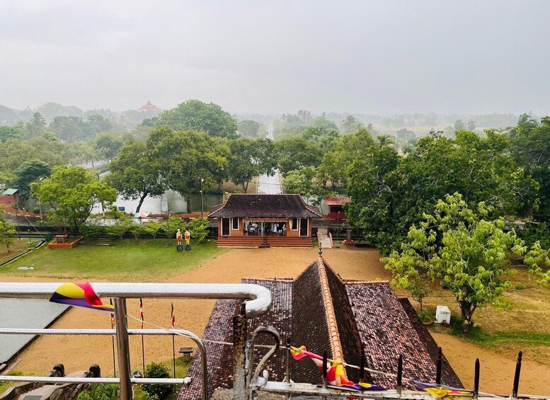 A traditional house with a tiled roof, surrounded by lush greenery and a body of water. 4