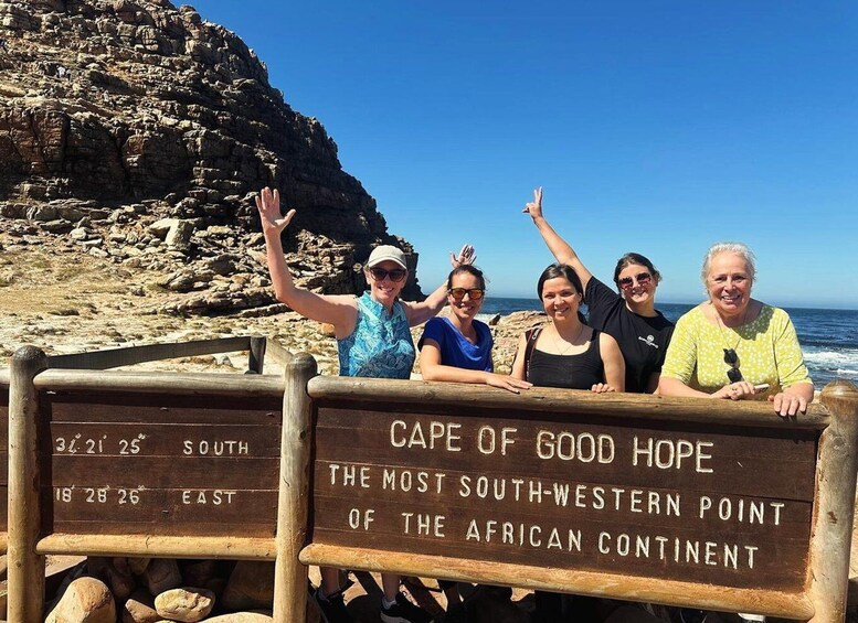 A group of people standing in front of a sign that reads "Cape of Good Hope, the most south-western point of the African continent." 1