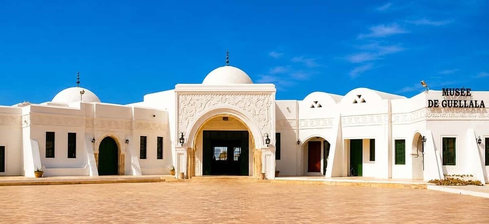 A white building with domes and arches, labeled 'MUSEE DE GUELLA'. 5