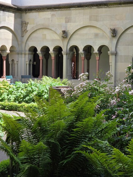 A courtyard with arches, columns, and lush greenery. 5