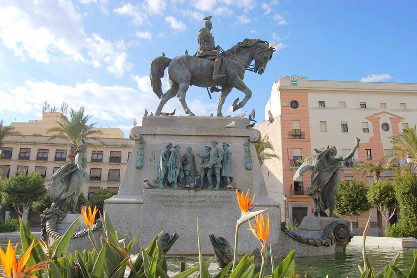 A statue of a man on horseback, a fountain, and a building in the background. 4