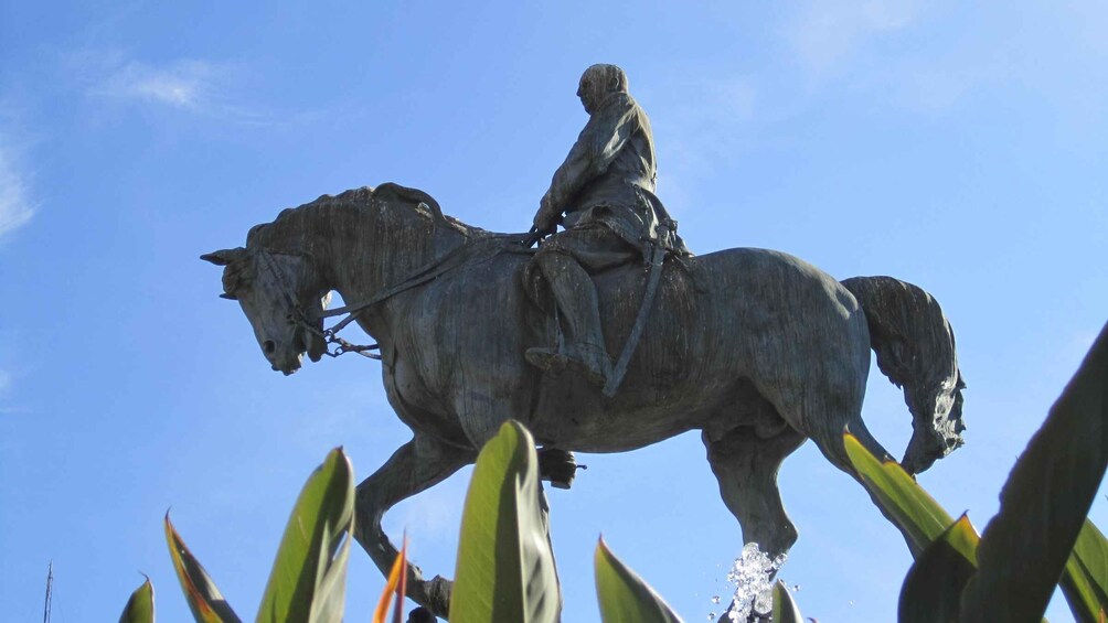 A statue of a person on horseback against a clear blue sky. 2