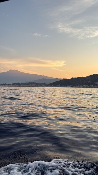 A calm lake with mountains in the background and a clear sky. 3