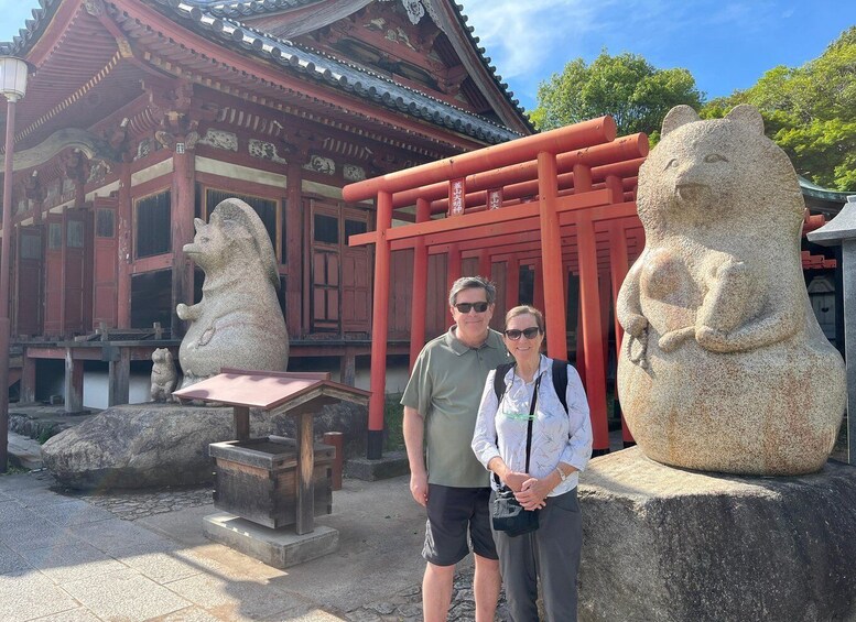A traditional Japanese building with red pillars and stone lion statues. 3