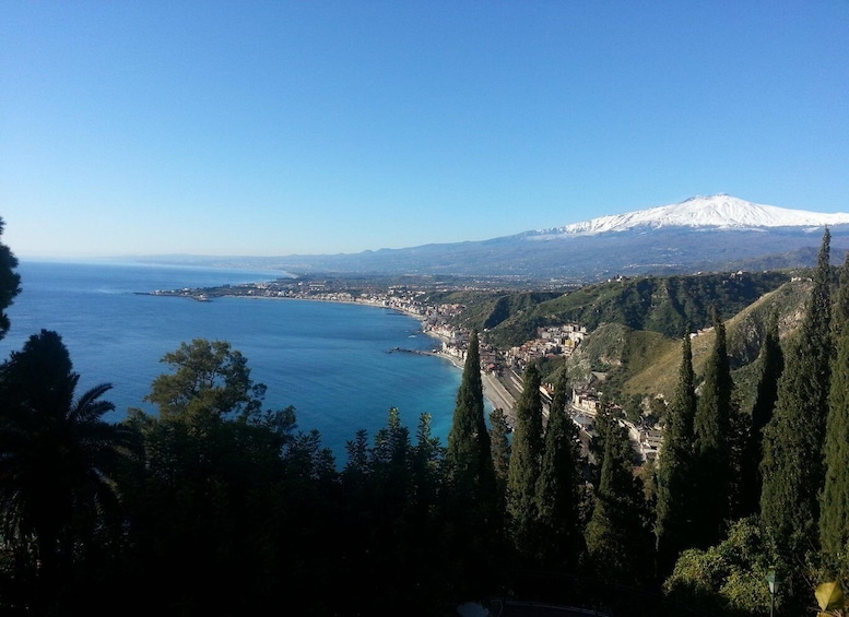 A coastal town with a snow-capped mountain in the background. 1