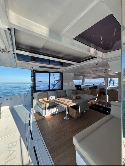 A modern boat interior with a dining area, kitchen, and seating. 4