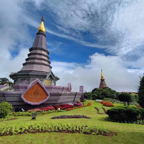A pagoda with a golden spire, surrounded by well-maintained gardens and a clear sky. 5