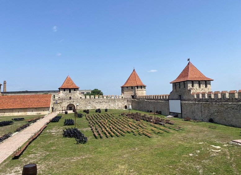 A historic castle with two towers and a courtyard with rows of chairs. 3