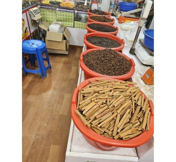 A spice market with large bowls of cinnamon sticks and black peppercorns. 1