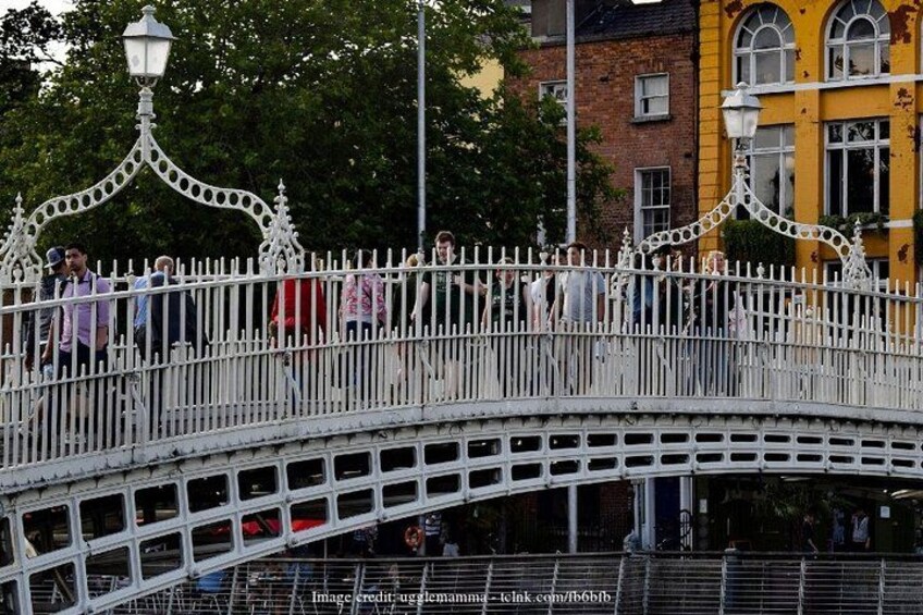 A white ornate bridge with pedestrians walking across it. 4