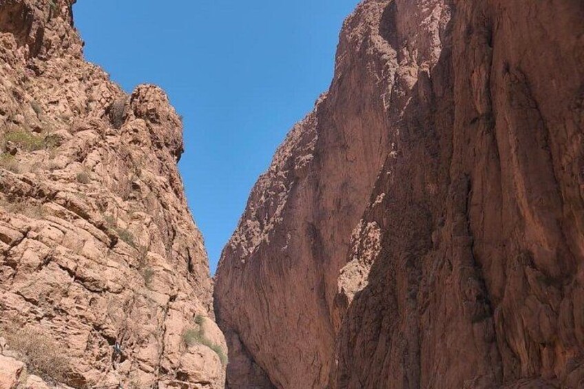 A canyon with steep rock faces and a clear blue sky. 5