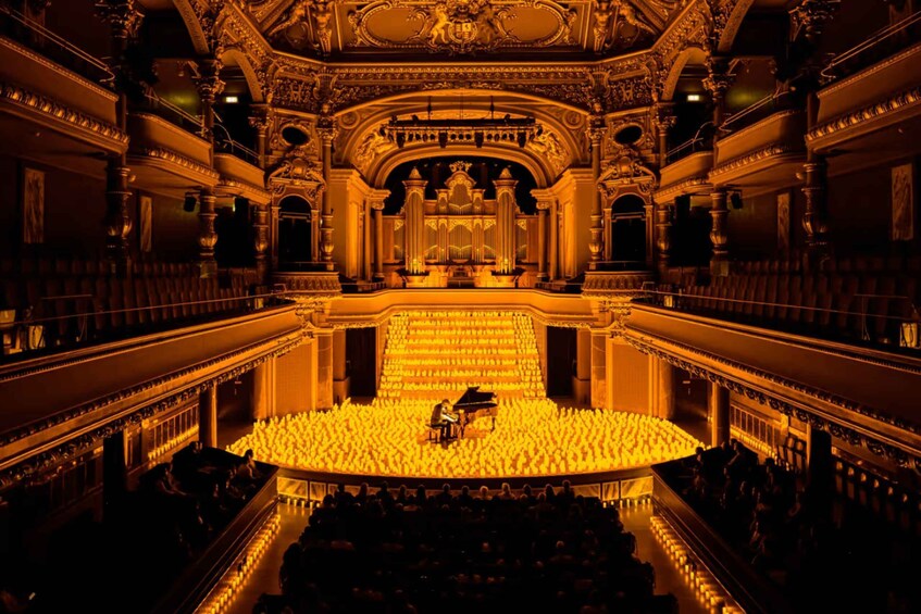 An ornate theater with a grand stage and a piano. 2