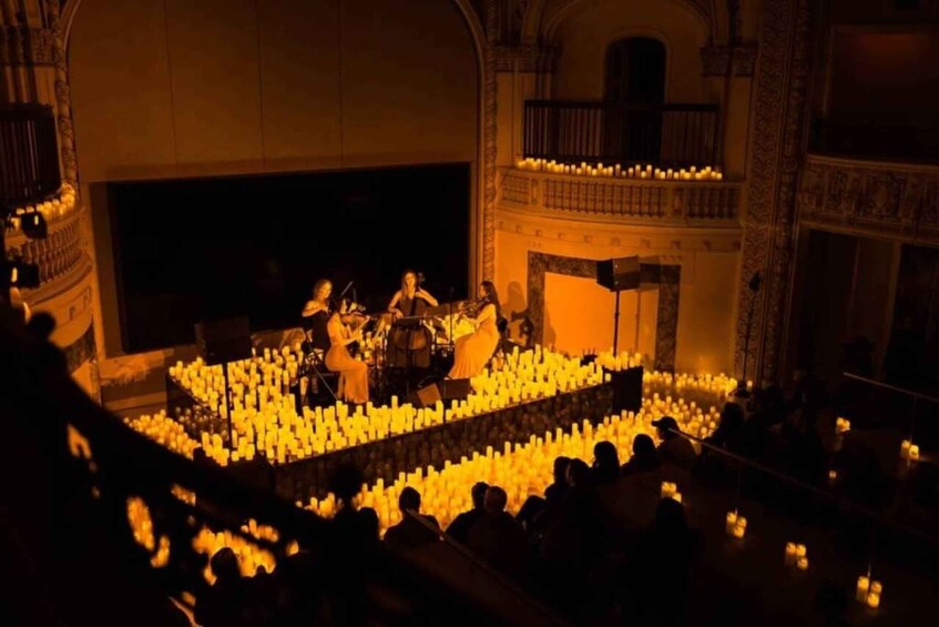 A concert with musicians on stage surrounded by candles. 5