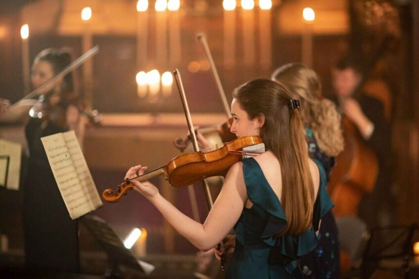 A violinist playing a violin with sheet music in a dimly lit room. 1