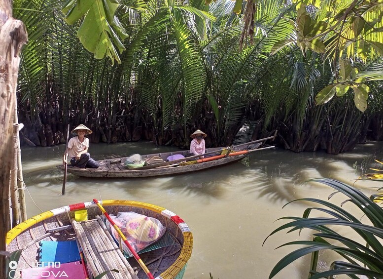 Two people in a narrow waterway surrounded by dense tropical vegetation. 3