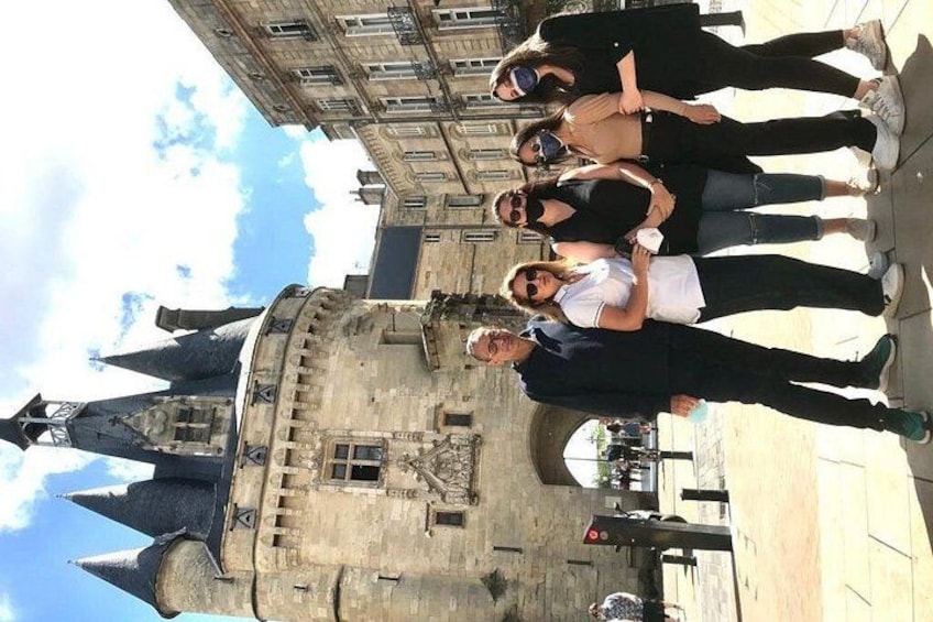 Un groupe de personnes se tient devant un bâtiment historique doté d’une tour avec une horloge. 5