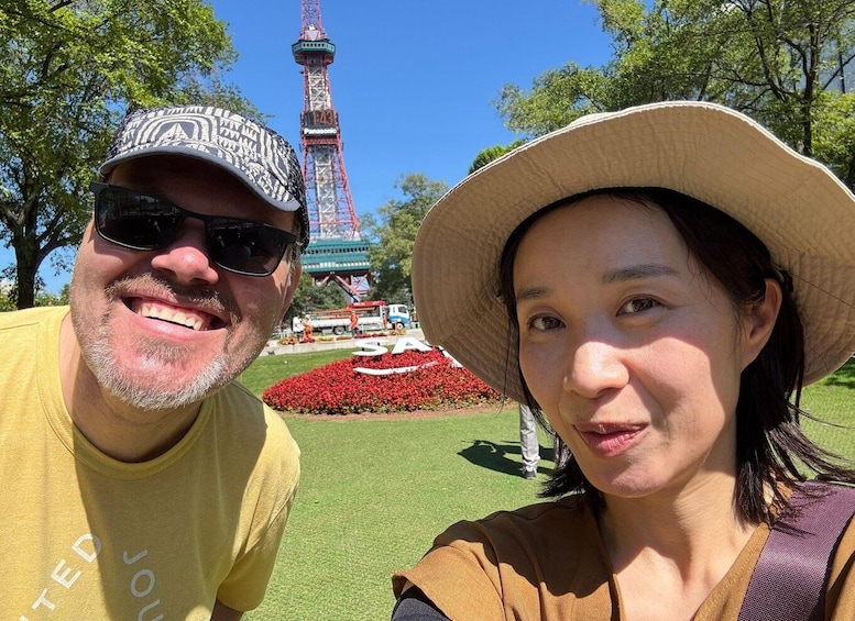 Two people in a park with a large tower in the background. 2