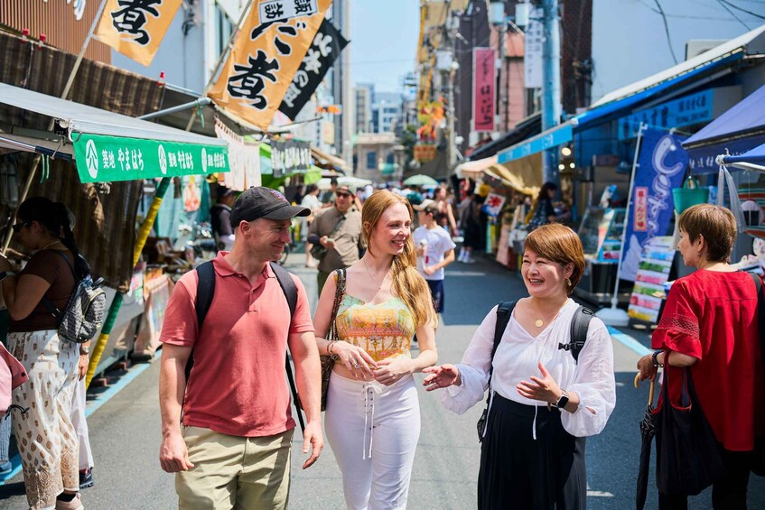 A busy street market with people walking and vendors selling goods. 3