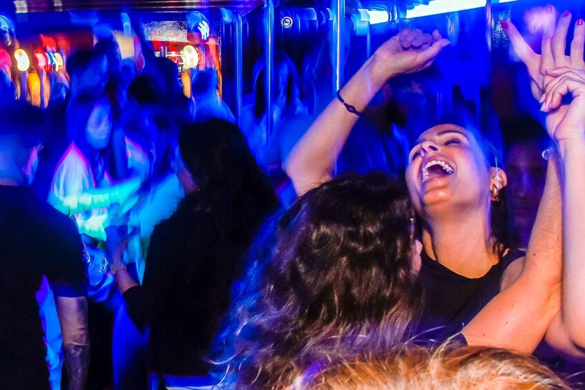 A crowded indoor event with people dancing and raising their hands. 5
