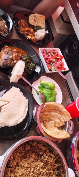 A variety of dishes including fish, rice, and vegetables on a table. 3