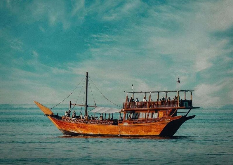 A wooden boat with passengers on a calm sea. 3