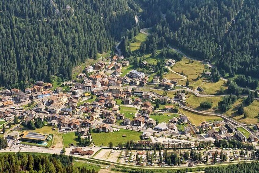 A mountainous town with dense forested areas, winding roads, and scattered houses. 3