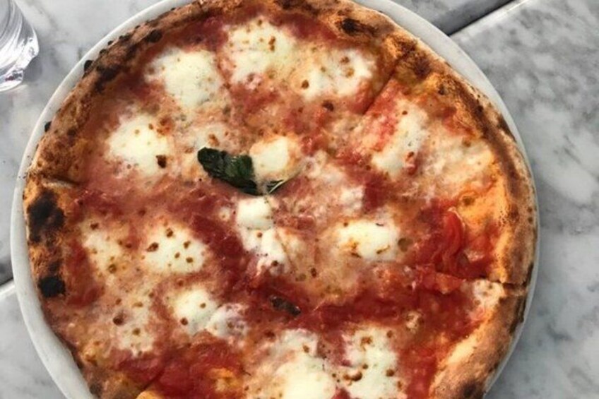 Pizza con queso derretido y salsa de tomate sobre un plato blanco. 5