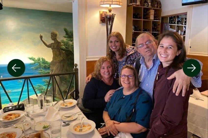 A group of people dining at a restaurant with a mural of a woman on the wall. 4
