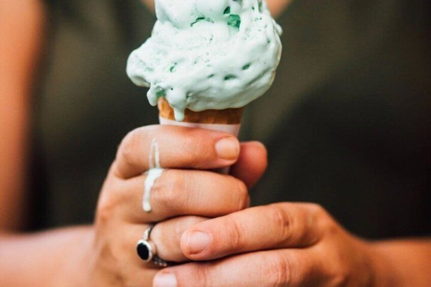 Una mano sosteniendo un cono con helado verde. 2