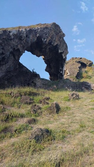 A large rock formation with a natural arch. 4