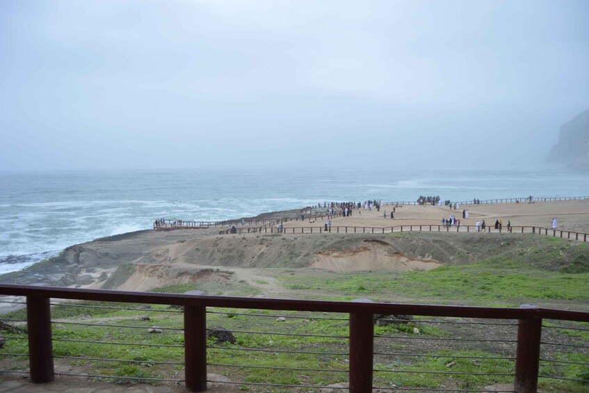 A coastal area with a rocky cliff, a sandy beach, and the ocean. 4