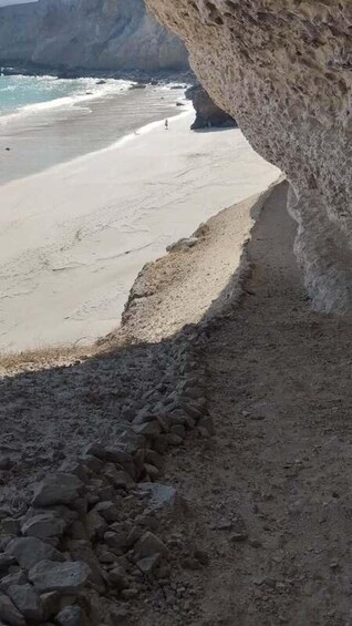 A rocky coastline with a beach and ocean. 3